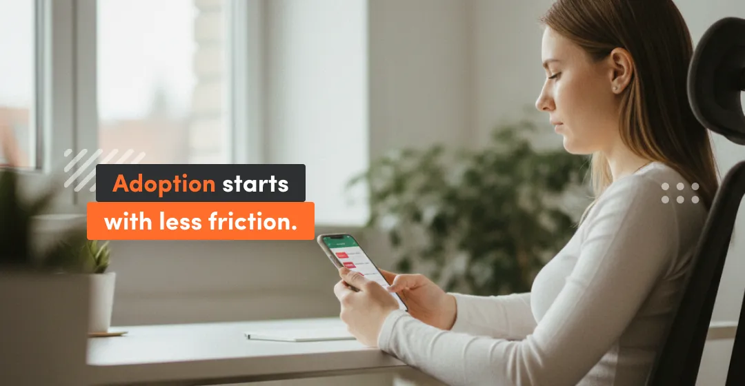 Employee using a phone at a desk—LMS adoption starts with less friction in a learning management system for employees.