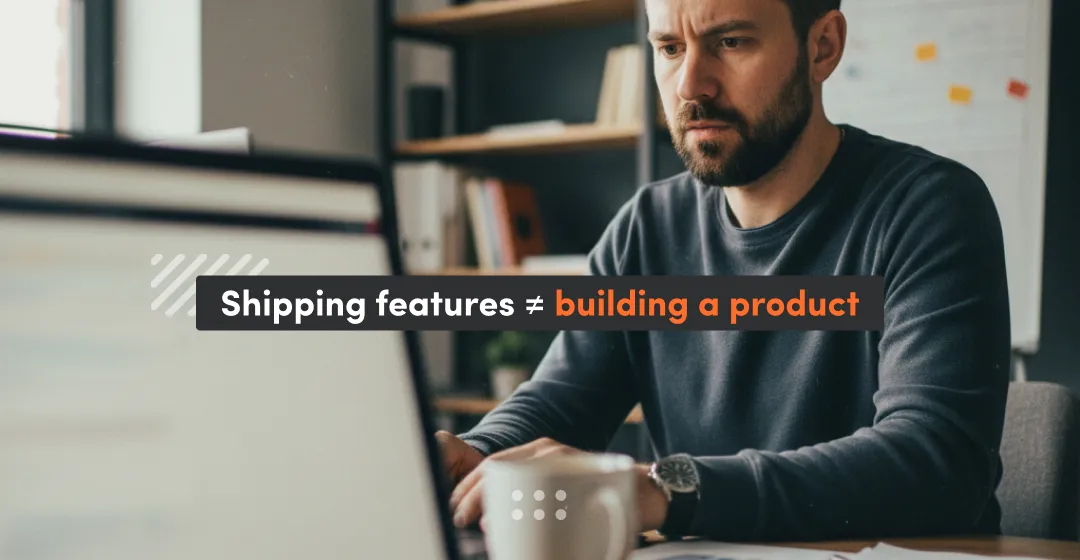 Photo of a man working on a laptop at a desk, with an overlay text that says “Shipping features ≠ building a product.”