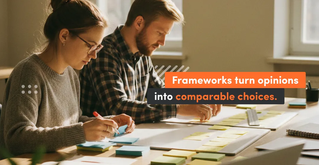 Two product managers work at a table covered in sticky notes, using a product management framework to prioritize features and turn stakeholder opinions into clear, comparable choices.