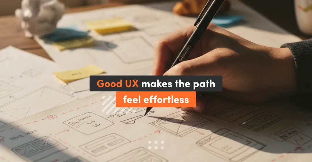 A person draws wireframes on paper with sticky notes scattered around, with the text “Good UX makes the path feel effortless,” illustrating how clear UX planning creates smooth and intuitive user journeys.