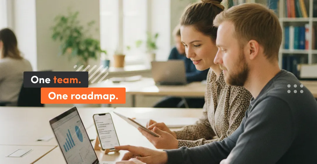 Product team working together on laptops and dashboards, representing one team and one roadmap in outsourced software development with shared ownership, priorities, and delivery control.