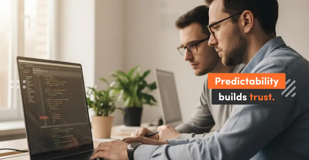 Two frontend developers reviewing React code using Redux Toolkit to ensure predictable state management and build trust through auditable, well-structured architecture.